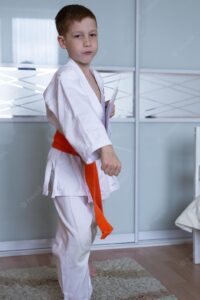 child-redhaired-boy-is-engaged-karate-training-kicks-home-form-kimono-with-orange-belt-children-s-sport-full-growth_530736-863.jpg